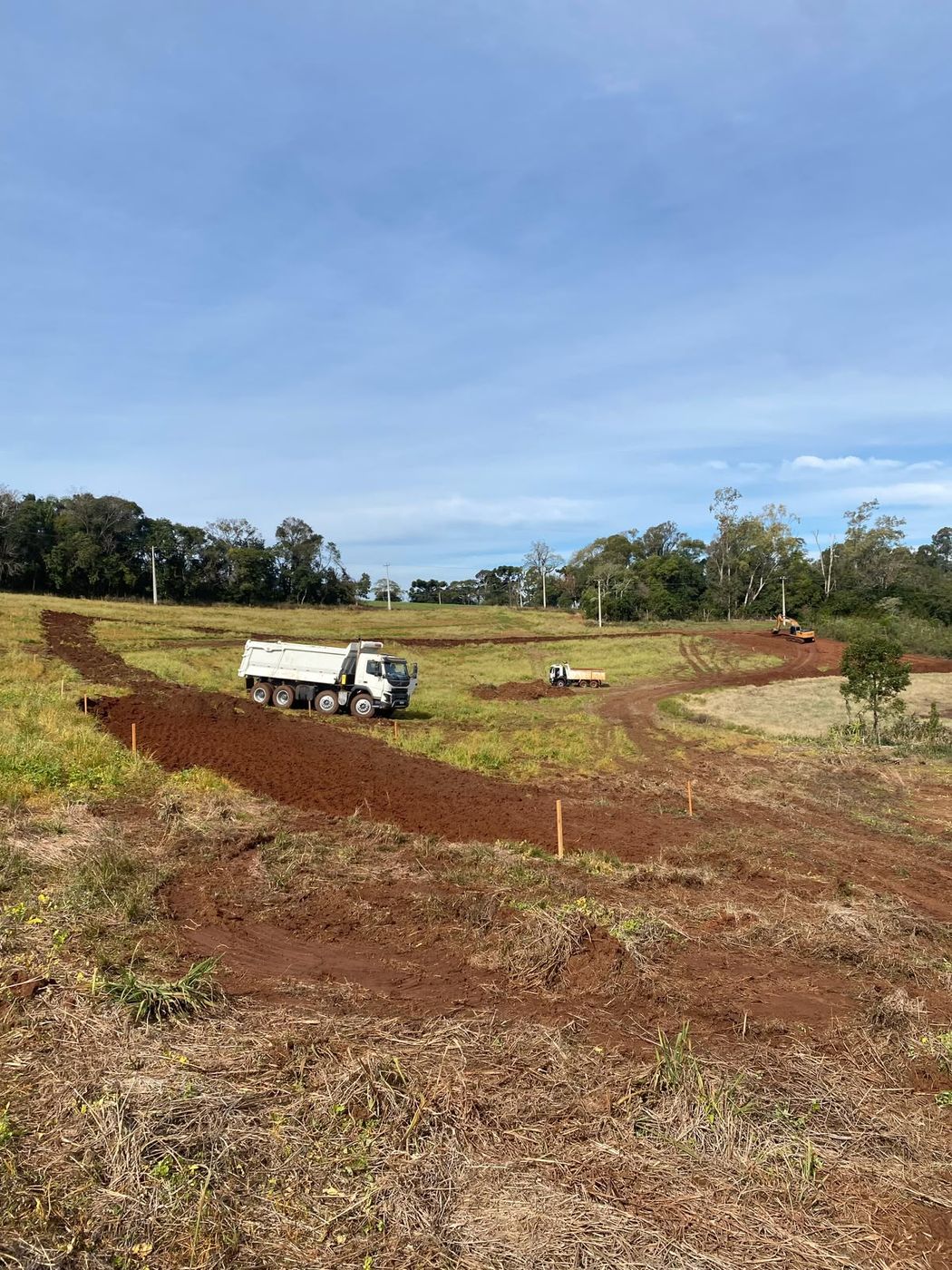 Caminhão caçamba retirando material de limpeza de terreno em propriedade rural