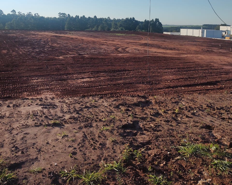 Área ampla já nivelada e compactada, pronta para receber obra, com marcas das máquinas na superfície regularizada